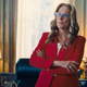 Meryl Streep wears red framed glasses and stands in a red dress suit with her arms crossed in the Oval Office in Don't Look Up.